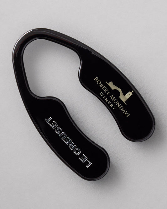 The black Robert Mondavi Winery x Le Creuset Foil Cutter on a gray background