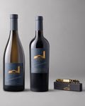 A bottle of Estates Fume Blanc and Estates Cabernet Sauvignon paired with a gold corkscrew.