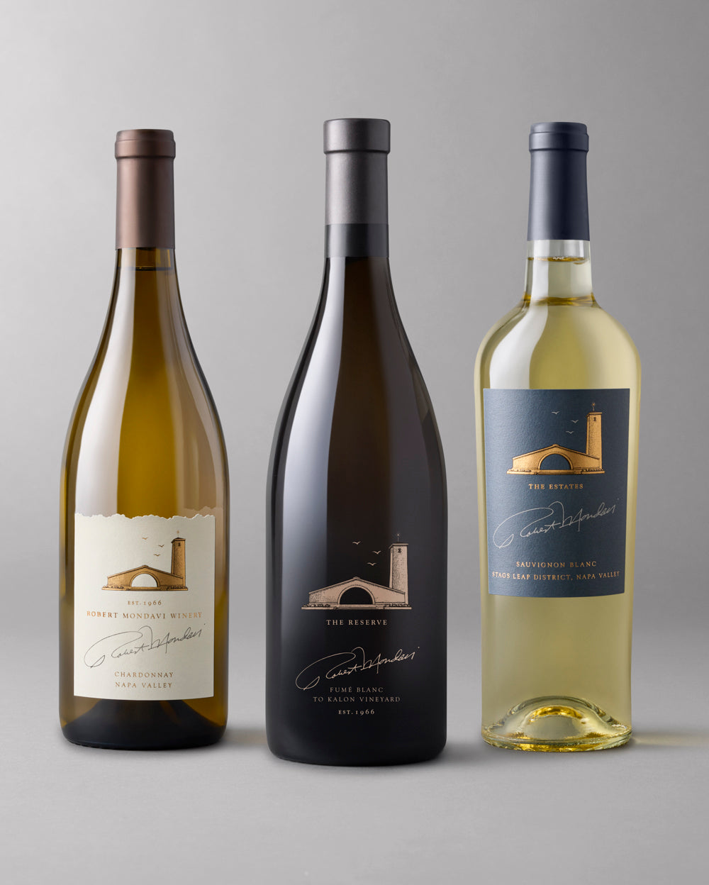 3 bottles of white wine on a grey background, Chardonnay, Fume Blanc and Sauvignon Blanc