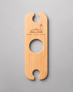 A wooden  Wine Butler that holds two glasses and balances on the neck of a bottle of wine.