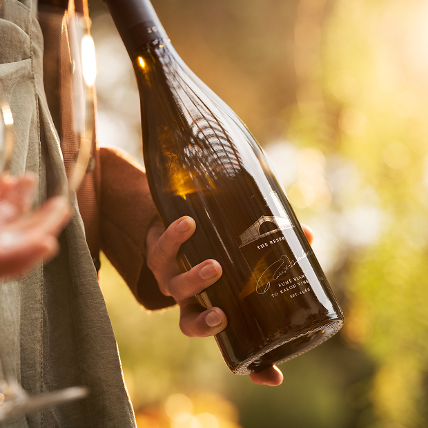 Close up of someone outside holding a bottle of Robert Mondavi Reserve Fume Blanc