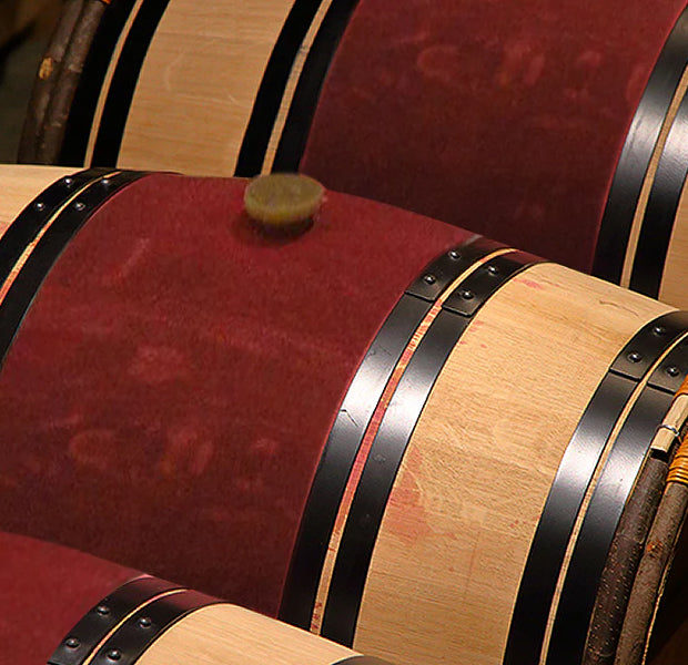 Close up image of wine barrels with a red stripe in the middle of the barrel