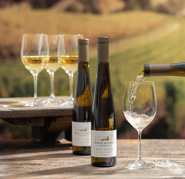 2 bottles of Robert Mondavi white wine with wine being poured in a glass 